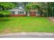 A cozy brick home features black shutters, complemented by a well-manicured lawn at 1401 Hillwood Ct, Charlotte, NC 28210