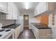 Efficient kitchen featuring white cabinets and a double-basin sink under a bright light fixture at 1401 Hillwood Ct, Charlotte, NC 28210