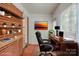 Home office space with custom brick shelving, desk, office chair, and large window with natural light at 1401 Hillwood Ct, Charlotte, NC 28210