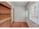 Spacious sunroom with terra cotta tile flooring, custom shelves, and bright, natural light from a large window at 1401 Hillwood Ct, Charlotte, NC 28210