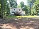 Backyard featuring a two-story white home with a wood deck and beautiful trees surrounding at 14027 Hackamore Dr, Matthews, NC 28105