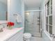 This bathroom features light-blue walls, shower with marble tile, and a window with bright light at 14027 Hackamore Dr, Matthews, NC 28105