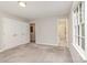 Neutral bedroom featuring carpet, a bright window, double closet and doorway to tiled bathroom at 14027 Hackamore Dr, Matthews, NC 28105