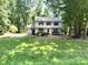 Traditional two-story home with a well-manicured lawn and mature trees at 14027 Hackamore Dr, Matthews, NC 28105
