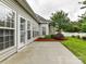 View of the backyard with a concrete patio, lush grass, mulched garden, privacy fence, and a grey home exterior at 147 Wren Hill Dr, Mooresville, NC 28115