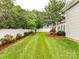 Lush green backyard featuring a privacy fence, mature trees, and landscaped garden beds at 147 Wren Hill Dr, Mooresville, NC 28115