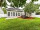 Backyard of home with well manicured lawn, patio, privacy fence, mulched garden, and home exterior at 147 Wren Hill Dr, Mooresville, NC 28115