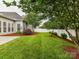 Backyard with lush green grass, mature landscaping, mulched garden beds and a privacy fence at 147 Wren Hill Dr, Mooresville, NC 28115