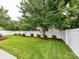Green backyard with fresh cut grass, landscaped garden beds, privacy fence, and mature trees at 147 Wren Hill Dr, Mooresville, NC 28115