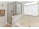 Bathroom featuring a soaking tub, glass enclosed shower, and a bright window at 147 Wren Hill Dr, Mooresville, NC 28115