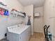 Well-lit laundry room with washer, dryer, storage shelves, and tiled flooring at 147 Wren Hill Dr, Mooresville, NC 28115