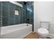 Modern bathroom features dark blue tiling, recessed shower niche, and a soaking tub at 1490 White Hall Pl, Gastonia, NC 28056