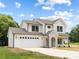 A pristine white two-story home with a stone-accented entrance, a two-car garage, and a well-maintained front lawn at 1490 White Hall Pl, Gastonia, NC 28056