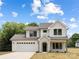 Charming two-story home featuring stone arched entry, attached garage, and manicured lawn, under a bright blue cloudy sky at 1490 White Hall Pl, Gastonia, NC 28056