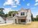 Beautiful two-story home with a stone archway entrance, two-car garage, and green lawn, bathed in sunlight at 1490 White Hall Pl, Gastonia, NC 28056