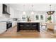 Contemporary kitchen featuring a central island with seating, white cabinetry, stainless appliances, and open to living areas at 1490 White Hall Pl, Gastonia, NC 28056