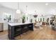 Modern kitchen featuring a large island with seating, white cabinetry, and open layout to dining and living areas at 1490 White Hall Pl, Gastonia, NC 28056
