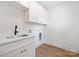 Well-lit laundry room featuring white cabinets, a sink, and a washer/dryer hookup at 1490 White Hall Pl, Gastonia, NC 28056
