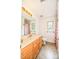 Bright bathroom featuring a single vanity with a large mirror, neutral-toned tile floor, and a floral patterned shower curtain at 15025 Barbee Rd, Stanfield, NC 28163