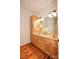 Well-lit bathroom with double sinks, oak cabinetry, and ample counter space at 15025 Barbee Rd, Stanfield, NC 28163