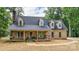 Detailed view of the brick home with a welcoming front porch and dormer windows at 15025 Barbee Rd, Stanfield, NC 28163