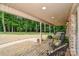 Relaxing covered front porch with wooden floors, perfect for enjoying the outdoors and views of the lush landscape at 15025 Barbee Rd, Stanfield, NC 28163