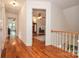 Hardwood hallway with white walls leading to rooms with ceiling fans and ample natural light in this well maintained home at 15025 Barbee Rd, Stanfield, NC 28163