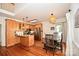 Bright kitchen with wooden cabinets, stainless appliances, and a rustic dining table set on beautiful hardwood floors at 15025 Barbee Rd, Stanfield, NC 28163