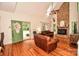 Cozy living room with leather sofas, a brick fireplace, hardwood floors, and a green front door at 15025 Barbee Rd, Stanfield, NC 28163