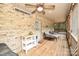 Covered porch with brick siding, string lights, neutral patio furniture, and a ceiling fan for comfortable outdoor living at 15025 Barbee Rd, Stanfield, NC 28163