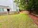 A view of the backyard with a grassy lawn, defined by a wooden fence and mulch bed at 1519 Briar Creek Rd # B, Charlotte, NC 28205