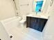 Modern bathroom featuring a tub, vanity with a dark wood cabinet, and white tile flooring at 1519 Briar Creek Rd # B, Charlotte, NC 28205