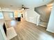 Open-concept living area with light wood floors, a fireplace, kitchen island, and a staircase leading to the second floor at 1519 Briar Creek Rd # B, Charlotte, NC 28205