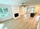 Bright living room featuring a fireplace, ceiling fan, light wood floors, and an open layout with a kitchen island at 1519 Briar Creek Rd # B, Charlotte, NC 28205