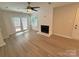 Bright living room featuring a fireplace, light wood floors, and natural light from the windows and glass doors at 1519 Briar Creek Rd # B, Charlotte, NC 28205