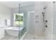Modern bathroom with a soaking tub, glass shower, and gray tile at 181 Lone Pine Rd, Statesville, NC 28625