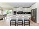 Bright kitchen features a large island with seating, white cabinetry, stainless steel appliances, and stone countertops at 181 Lone Pine Rd, Statesville, NC 28625