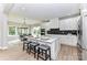 Bright kitchen features a large island with seating, white cabinetry, stainless steel appliances, and stone countertops at 181 Lone Pine Rd, Statesville, NC 28625