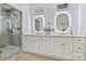 Elegant bathroom with double vanity, framed mirrors, and a glass shower with marble tiling at 1834 Arnold Dr, Charlotte, NC 28205