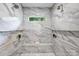 Luxurious shower featuring marble tiling, dual shower heads, a bench, and a window at 1834 Arnold Dr, Charlotte, NC 28205