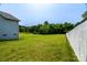 Large grassy backyard with a partial fence, trees, and view of the home at 1858 Brevard Place Rd, Iron Station, NC 28080