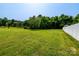 Expansive backyard featuring lush green grass, mature trees and a white fence at 1858 Brevard Place Rd, Iron Station, NC 28080
