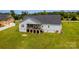 Back exterior of home, showing large yard and deck, wooden stairs, and grey siding at 1858 Brevard Place Rd, Iron Station, NC 28080