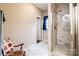 Tiled shower stall and a chair near window in updated bathroom at 1858 Brevard Place Rd, Iron Station, NC 28080
