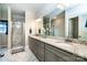 Bathroom featuring double sinks with granite vanity, a large mirror, and tiled shower at 1858 Brevard Place Rd, Iron Station, NC 28080