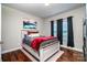 Cozy bedroom featuring a bed with wooden frame, dark curtains, and hardwood floors at 1858 Brevard Place Rd, Iron Station, NC 28080