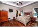 Primary bedroom featuring hardwood floors, a ceiling fan, and large windows at 1858 Brevard Place Rd, Iron Station, NC 28080