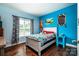 Bright bedroom with blue walls, hardwood floors, bed with Pokémon themed decor and natural light at 1858 Brevard Place Rd, Iron Station, NC 28080
