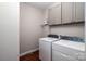 Well-lit laundry area featuring a washer, dryer, and overhead cabinets at 1858 Brevard Place Rd, Iron Station, NC 28080
