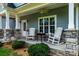 Inviting front porch with rocking chairs, stone accents, and space for relaxation at 1858 Brevard Place Rd, Iron Station, NC 28080